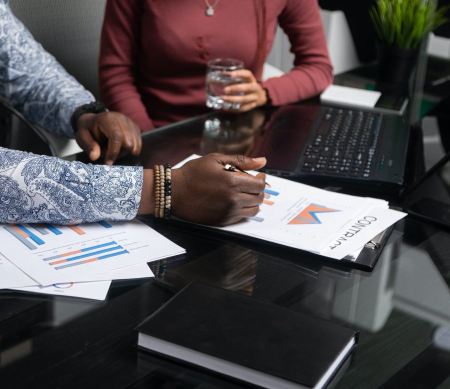 two young black people discuss their business using diagrams sitting at Desk in the office